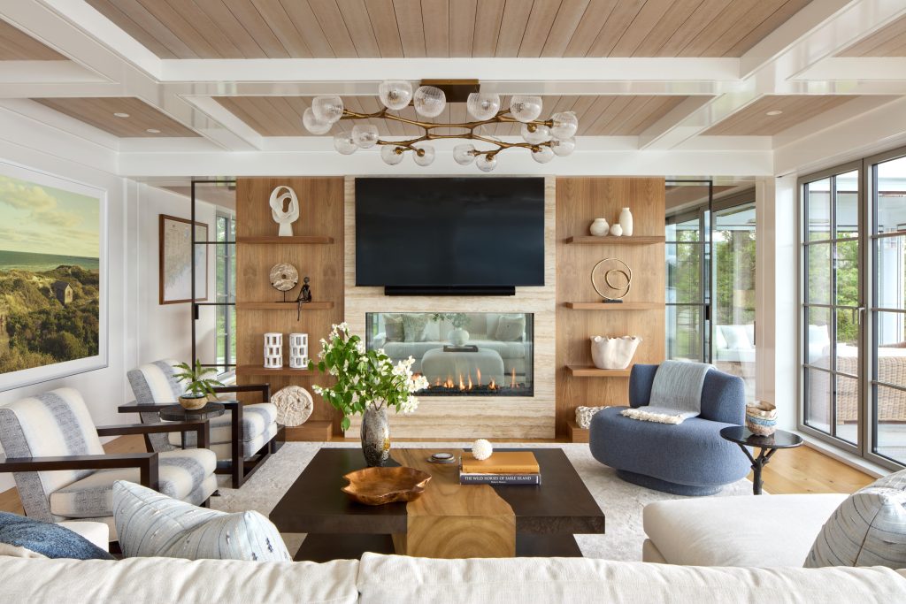 Coveledge living room with three sofa chairs, one couch, a coffee table, a tv mounted on the wall, and fireplace